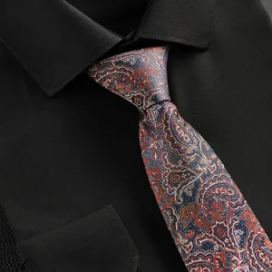 Close-up detail of a vintage paisley pattern men necktie paired with a classic black dress shirt.