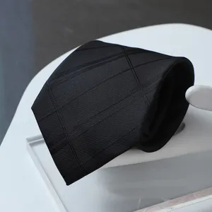 Detailed shot of a black geometric patterned tie, premium business menswear accessory.