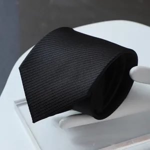 Detail view of a classic black formal necktie with fine twill texture for business suit.