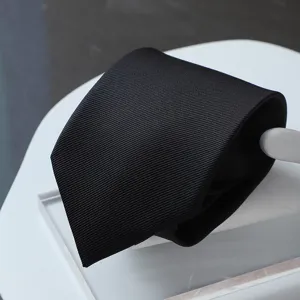 Detail shot of a black formal business necktie with fine twill texture and neat folding.