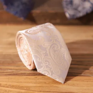 Detailed close-up view of a classic champagne paisley necktie showcasing fine fabric texture.