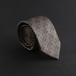 Close-up detail of a vintage patterned men's necktie rolled up on textured leather.