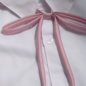 JK uniform white shirt with pink ribbon bow tie detail close-up view fashion accessory