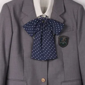 JK uniform gray blazer detail with a cute navy blue polka dot bow tie and classic school crest.