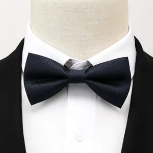 Gros plan détaillé d'un nœud papillon texturé bleu foncé classique sur chemise blanche.