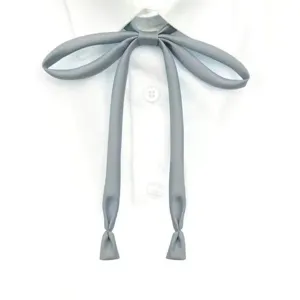 Detail view of a grey JK uniform tie ribbon, pre-tied college style neckwear accessory.