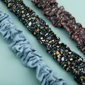 Primer plano detallado de correas de bolso de tela plisada y cadenas de teléfono de colores.
