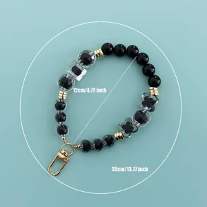 Black and clear beaded phone lanyard strap with cute heart and flower charms for women.