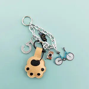 Detail shot of cute cat paw keychain with sparkling rhinestones, black cat and bicycle charms.