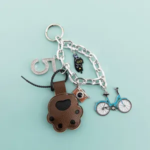Cute cat paw keychain with bicycle and number 5 charms, metal bag pendant accessory detail.