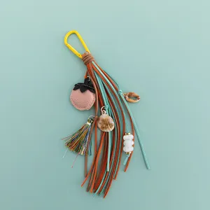 Breloque de sac à franges DIY avec pampilles en cuir, coquillage et adorable pendentif fruit.
