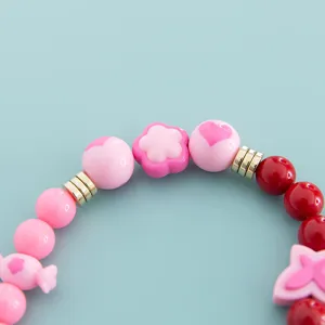 Close-up detail of colorful candy style beaded bracelet accessories with cute charms.