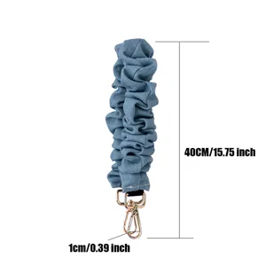 Correa de bolso de mezclilla azul fruncida asa corta para bolso con mosquetones dorados.