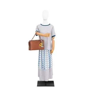 Detail view of the brown leather handbag with cute cat paw charm and keychain displayed on mannequin.