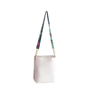 Sac seau style bohème élégant avec tissu floral unique et sangle en pierre perlée.