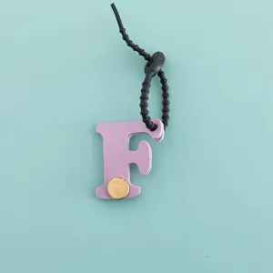 Porte-clés lettre F en cuir PU avec rivet métallique et lanière noire minimaliste.