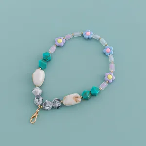 Bunte Acryl Perlen Handykette Detailansicht mit Blumen und Marmor Muster sowie goldenem Karabiner.