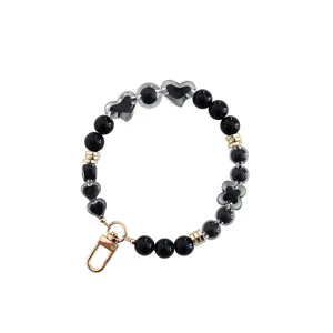 Black and clear beaded phone charm strap with heart and clover beads and gold lobster clasp.