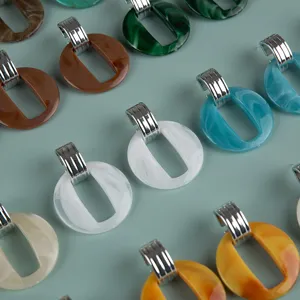 Detailed view of colorful acrylic hoop earrings with metallic clasps, stylish fashion jewelry.