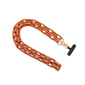 Matte orangefarbene Handtaschenkette und Handyketten-Gurt mit goldener Hardware im Trend.