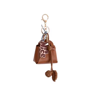 Mini brown leather bag keychain pendant with cute nice charm and metal hardware ring keyring.