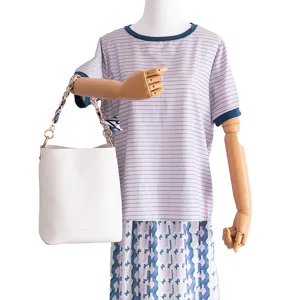 Bolso cubo blanco con elegante correa entrelazada de cadena metálica y pañuelo para estilo diario.