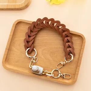 Courroie de sac tressée en cuir PU marron avec des pièces dorées et une perle élégante.