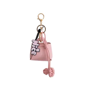 Detailed view of the pink PU leather mini bag keychain pendant with gold hardware and charm.