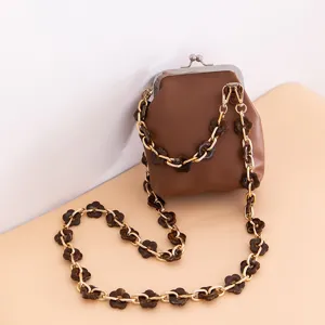 Detailed view of the stylish brown kiss lock bag featuring elegant acrylic flower chain straps.