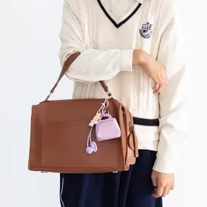 Brown PU leather handbag with purple mini coin purse pendant and knot charm accessory detail.