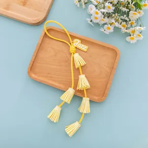 Yellow PU leather tassel keychain detail, stylish bag charm with letter pendant accessory.