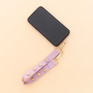 Elégante lanière de poignet de téléphone en cuir PU violet avec rivets de fleurs dorées