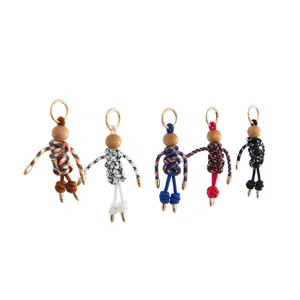 Handmade woven rope puppet keychain detail showing colorful cute doll charms with metal rings.