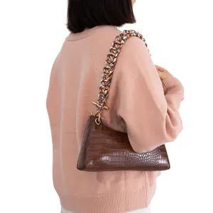 Detailaufnahme der stilvollen braunen Hobo-Tasche mit buntem geflochtenem Riemen und Metall.