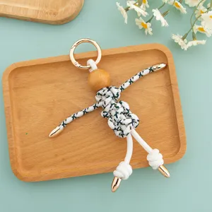 Detailed view of handmade rope woven wooden puppet keychain, creative quirky bag pendant accessory.