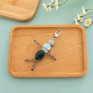Handcrafted beaded doll keychain cute bag charm quirky accessory for car keys and daily use.