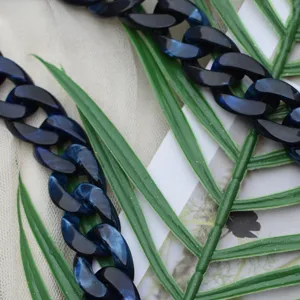 Detailed view of blue black acrylic chain strap for bag, stylish resin link accessory design.