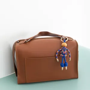 Handcrafted colorful rope puppet keychain detail view, cute bag pendant accessory charm.