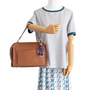 Brown shoulder bag with blue rope woven puppet charm accessory for women daily use