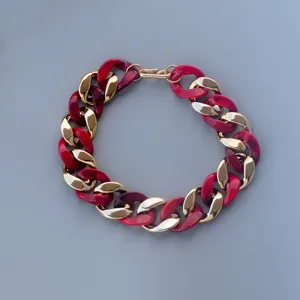 Detailed view of chunky acrylic and gold chain necklace, featuring bold red links for style.