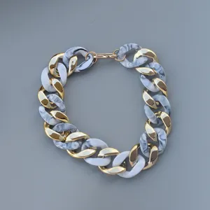 Chunky chain necklace with gold metal and marble acrylic links for women fashion jewelry.