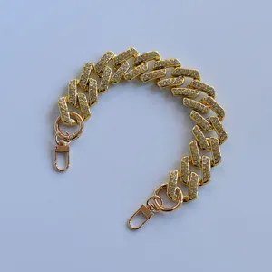 Gold rhinestone Cuban chain strap, sparkling bag accessory and decorative phone case chain detail.