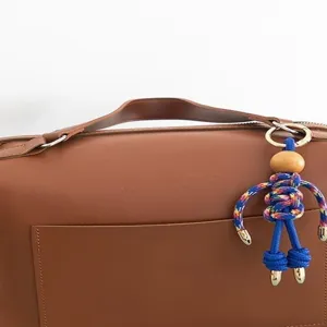 Handmade paracord doll keychain backpack accessory, creative puppet charm for bags and phones.
