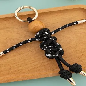 Handmade paracord doll keychain with wooden bead head, cute bag pendant and phone charm accessory.