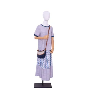 Detailed view of fashionable crossbody bag with amber acrylic chain worn on mannequin outfit.