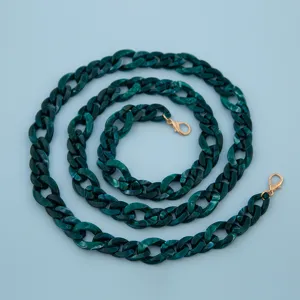 Detailed view of dark green acrylic chain strap with gold clasps for bags and phone cases.