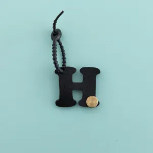 Vue rapprochée du porte-clés minimaliste en cuir PU lettre H et pendentif de sac à main.