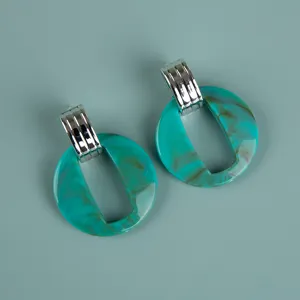 Detail view of large oversize acrylic marbled earrings with silver metallic top clips.