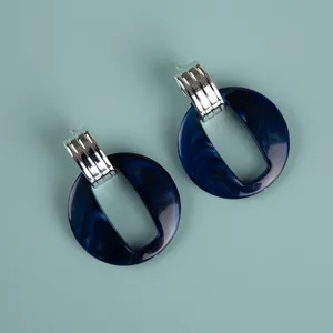 Blue acrylic and silver metal statement earrings detailed close-up shot for modern style.