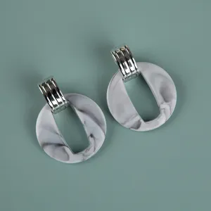 Detailed close-up of oversize grey marble acrylic earrings with silver metal connector.